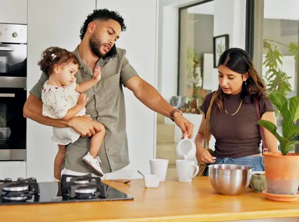 Busy family working in kitchen while on phone