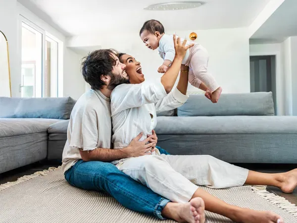 Parents holding their baby in the air